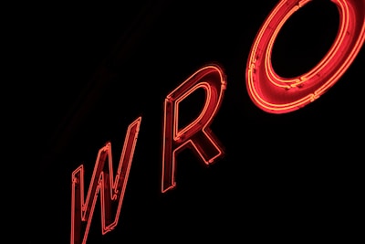 Neon red letters forming the partial word 'WRO' against a dark background, creating a glowing effect.