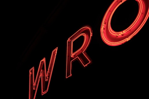 Neon red letters forming the partial word 'WRO' against a dark background, creating a glowing effect.