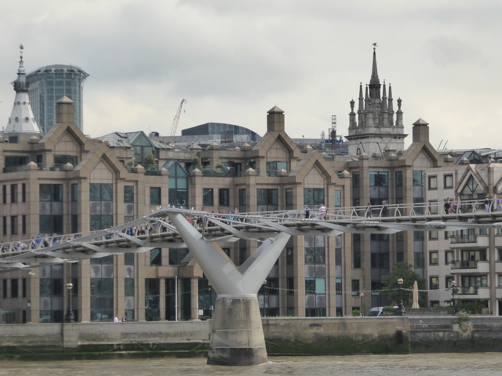 a bridge over a body of water with a building in the background