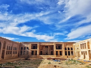 brown concrete building under blue and white sky at daytime
