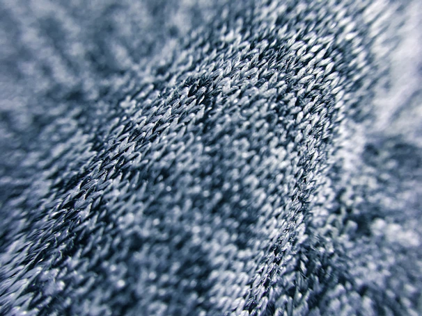 Close-up of dusty slate fabric with subtle stitching details highlighting original pattern work