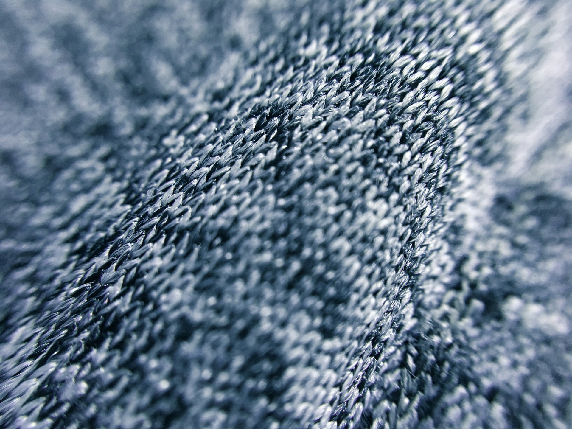 Close-up of textured fabric layers in neutral tones, highlighting intricate stitching and design.