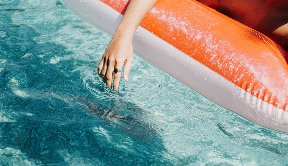 une personne flotte dans une piscine avec un radeau gonflable
