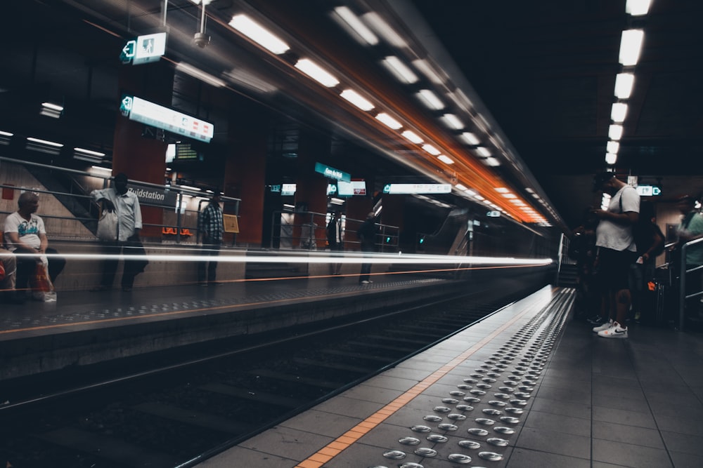 people standing at the subway station waiting for train