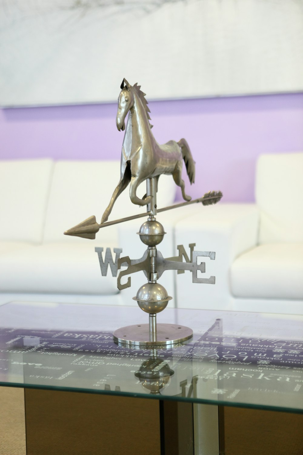 gray metal wind compass with horse figurine