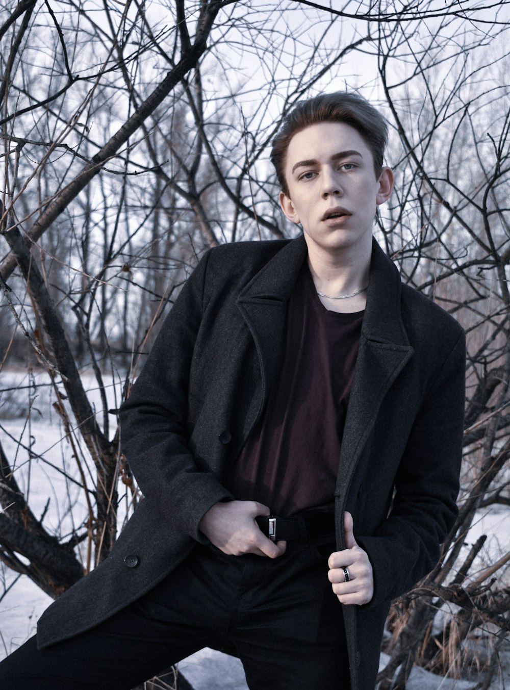 man in brown shirt and black pants with black coat