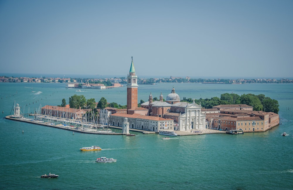 brown and white buildings surrounded by body of water at daytime