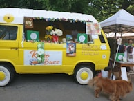 The Woof Wagon parked in a neighborhood street, decorated with paw prints and bright colors.