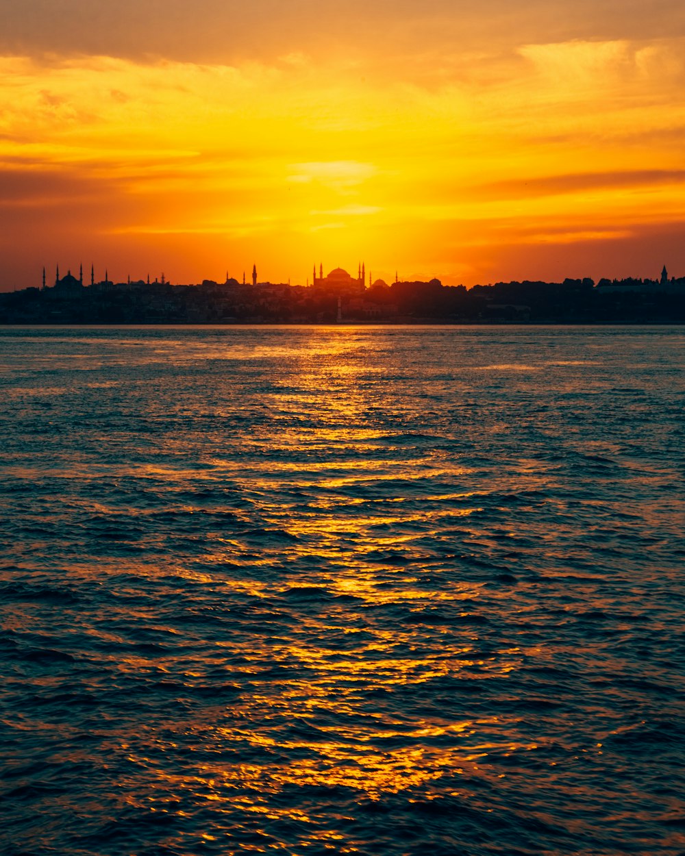 a large body of water with a sunset in the background