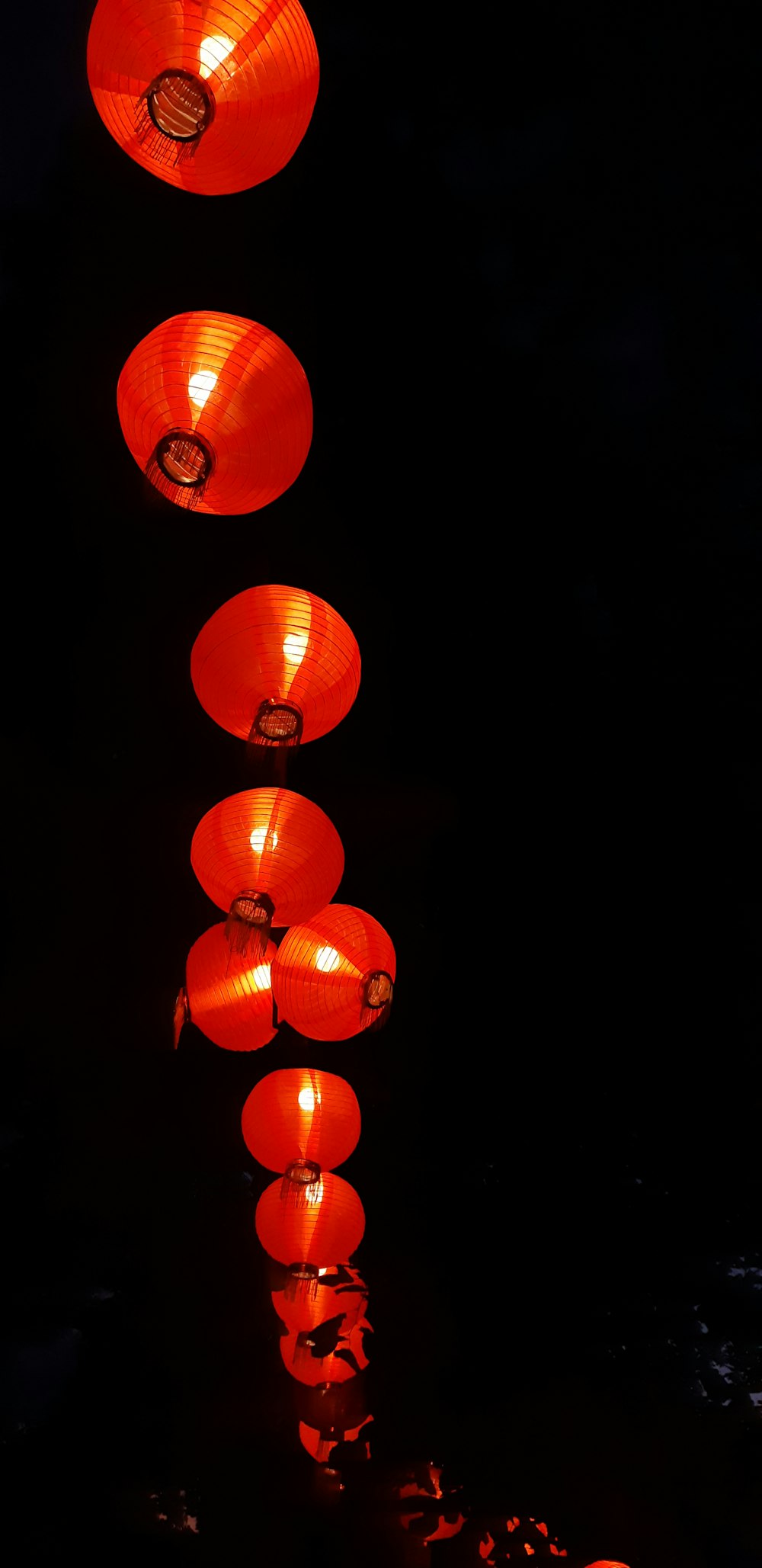a row of red lanterns hanging from a ceiling