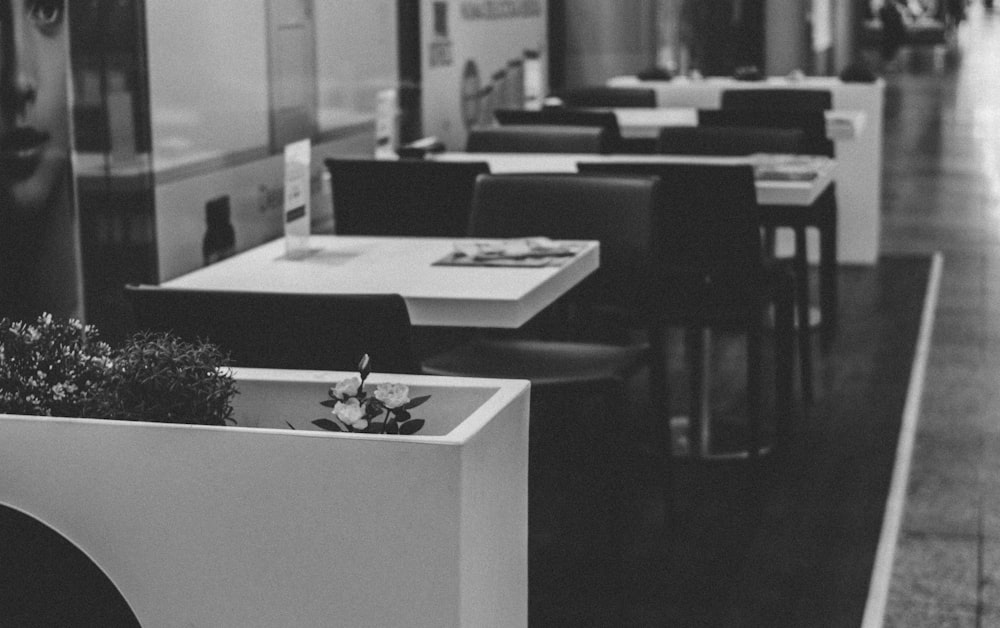 grayscale photo of empty restaurant tables