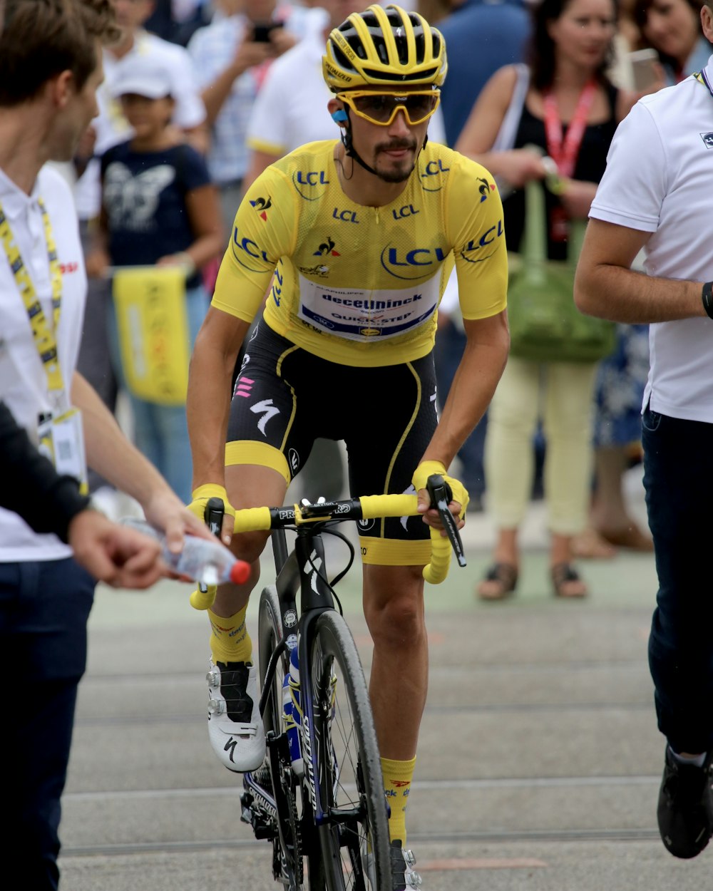 man in yellow shirt riding road bike