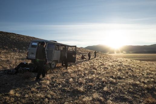 A group of volunteers setting up a mobile medical unit in a rural village at sunrise.