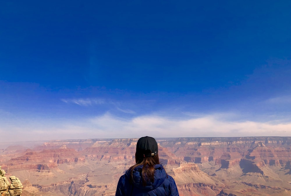 woman wearing blue hoodie standing in front of mountain view