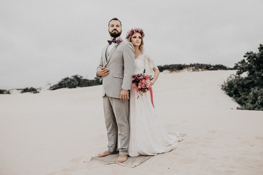 married couple standing on beach