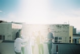 A group of friends in Lumina Apparel outfits enjoying a sunny city rooftop.