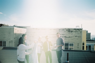 A group of friends in Lumina outfits laughing on a city rooftop at sunset.