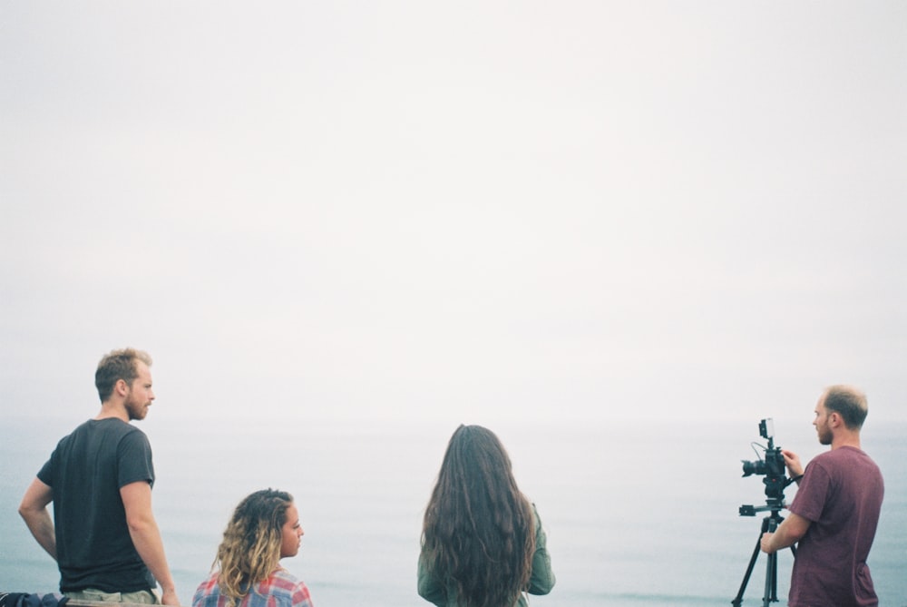 man facing black DSLR camera with tripod