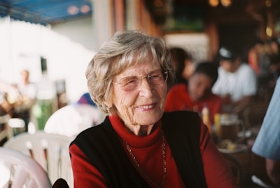 smiling woman in red sweater and black vest
