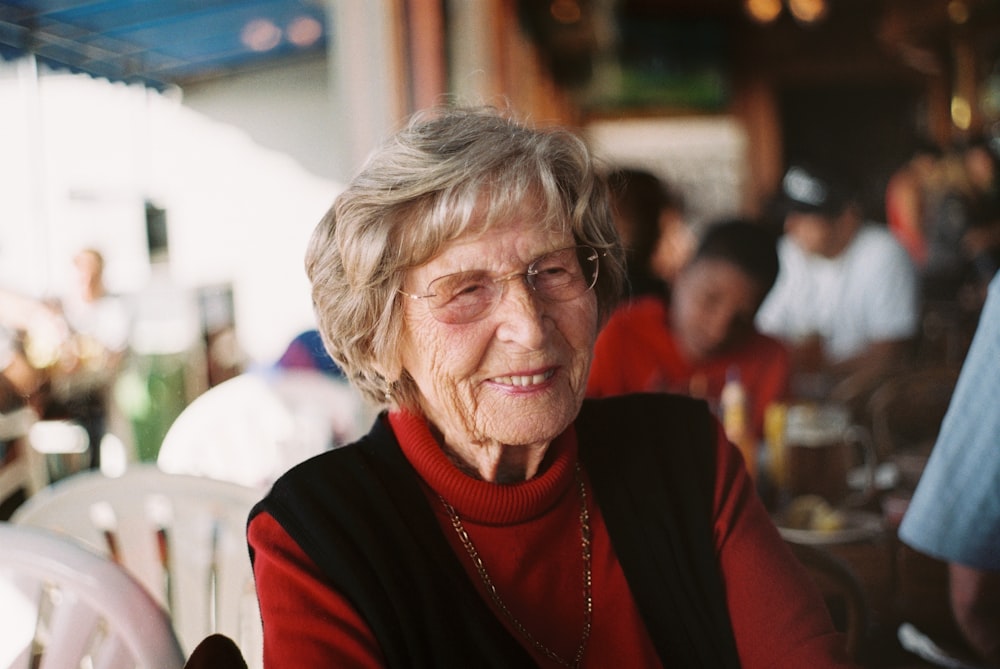 smiling woman in red sweater and black vest