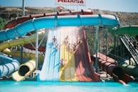 Thrill-seekers zooming down a tall, twisting water slide with joyful expressions.