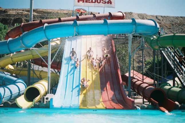 Children laughing and sliding down the Crown Rush 42 water slide on a sunny day
