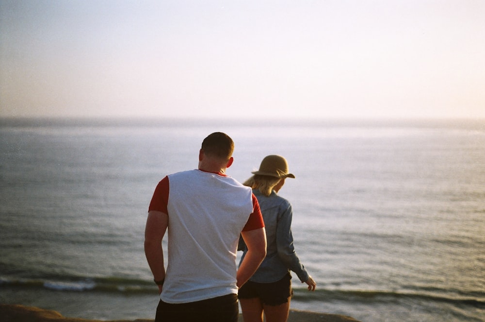 man and woman standing near body of water