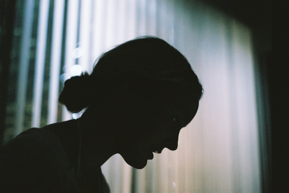 a silhouette of a woman using a cell phone