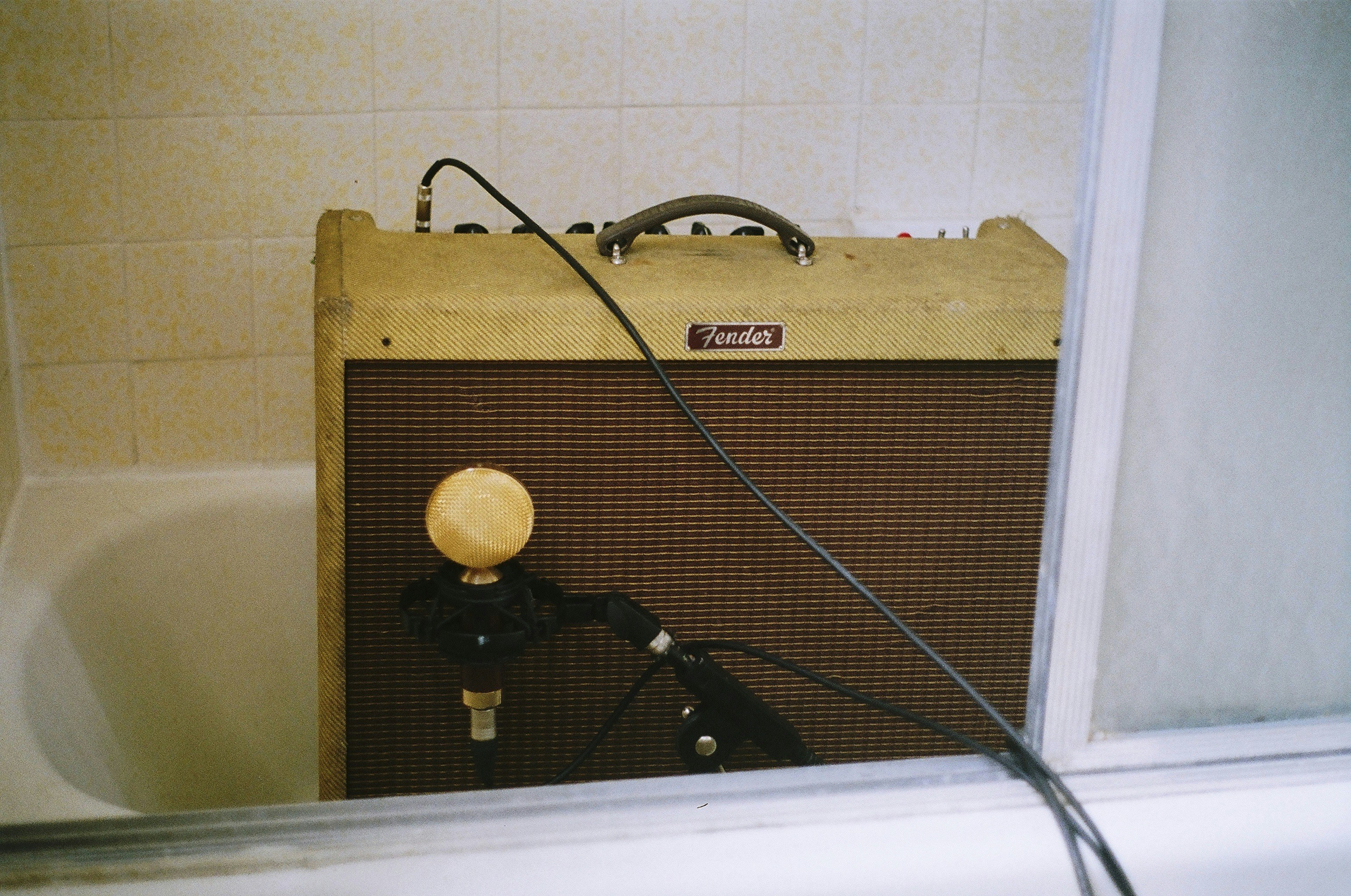 brown guitar amplifier on bath tub