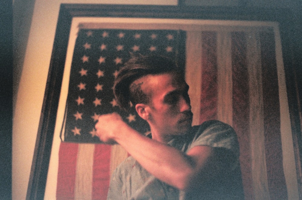 immagine incorniciata in legno nero di un uomo e di una bandiera americana