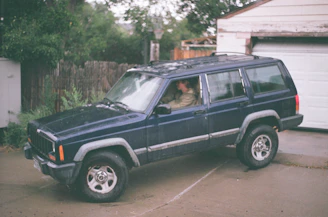 A certified specialist observing a client during a driving evaluation in a calm suburban setting.