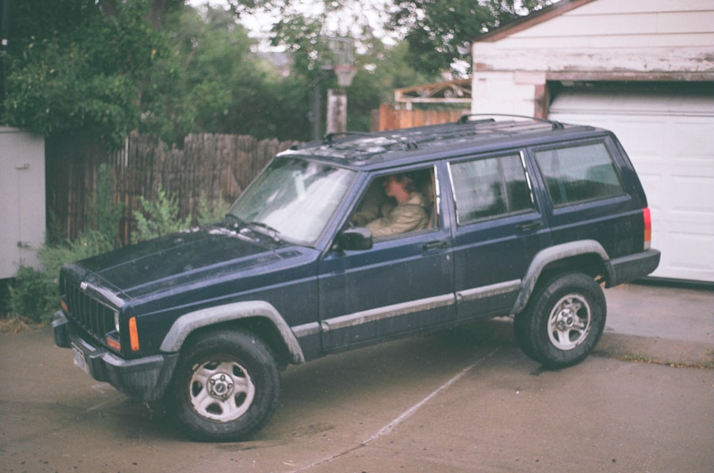 blue SUV in road during daytime