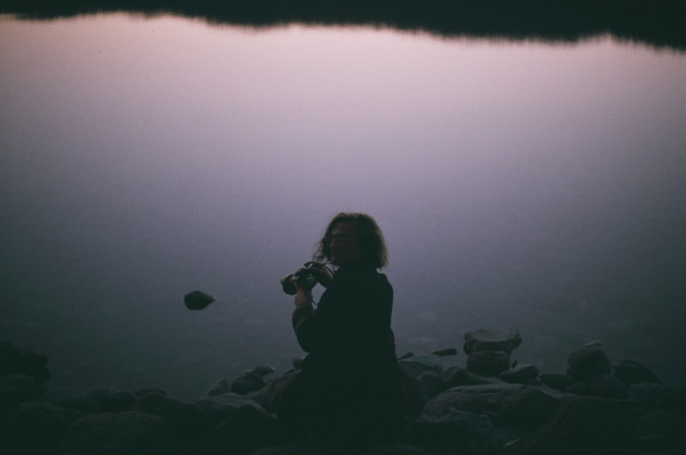 woman sitting near body of water