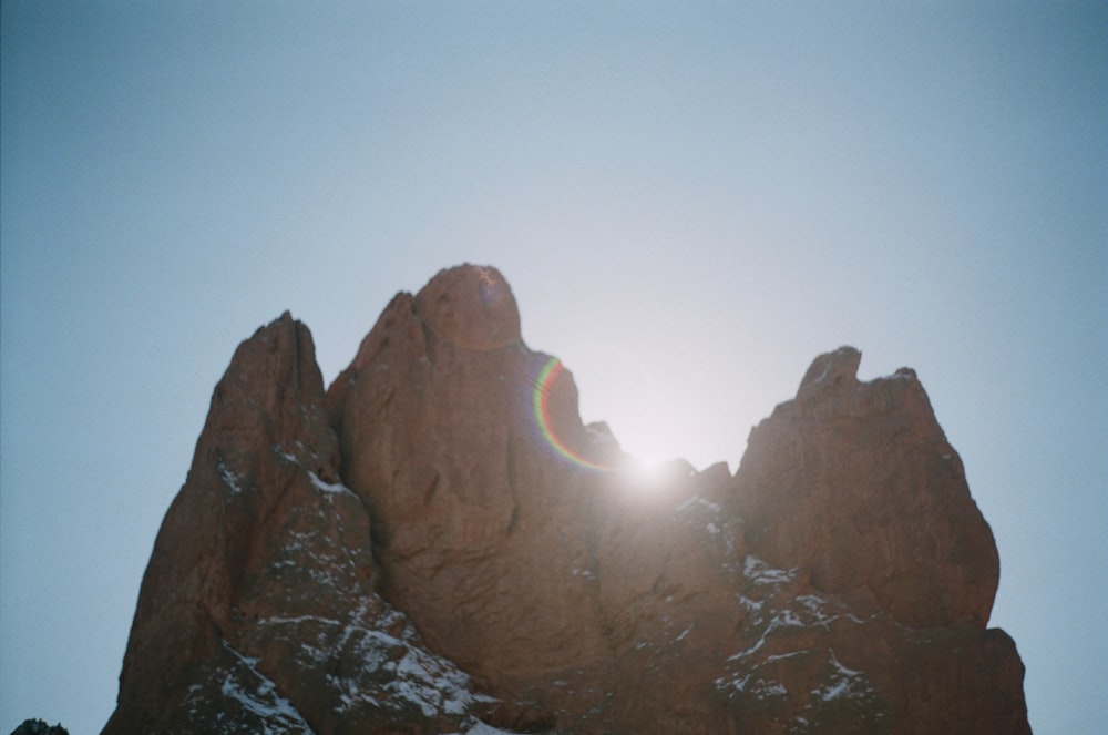 the sun shines brightly through the rocks of a mountain