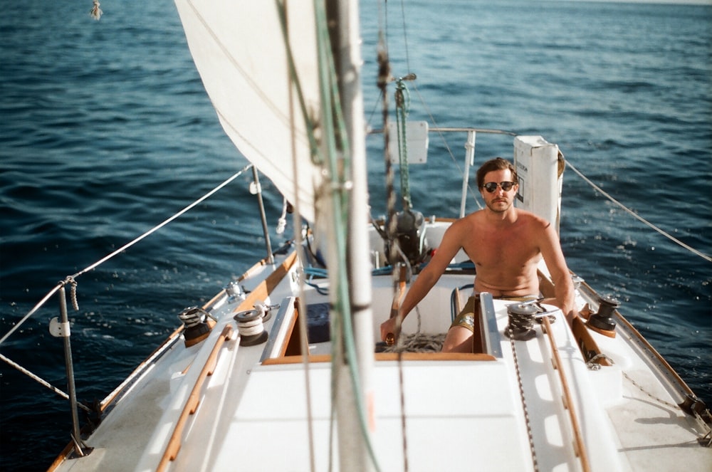 man riding white sail boat during daytime