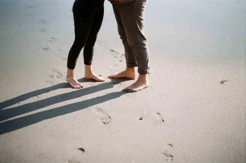 man and woman standing on seashore during daytime