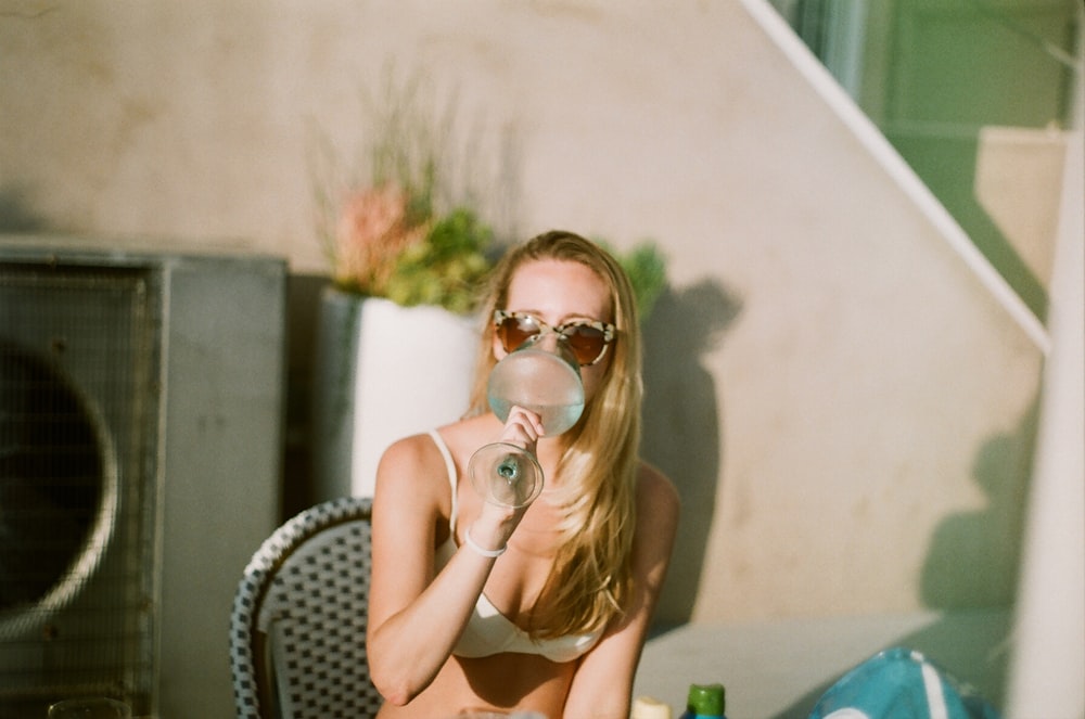 woman in yellow bikini sitting and drinking beverage