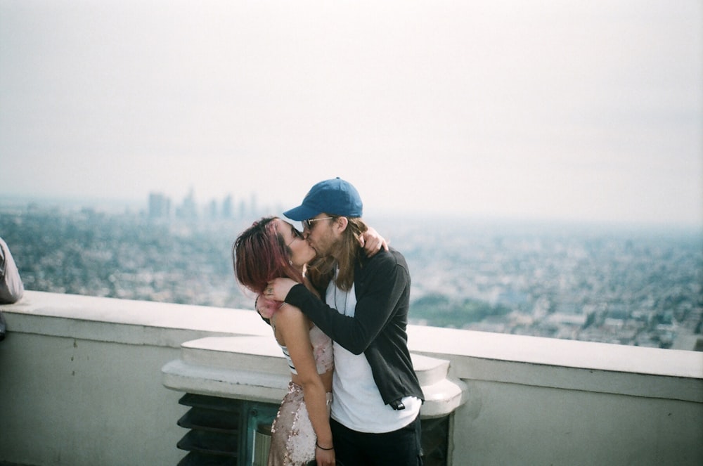 man and woman kissing on focus photography