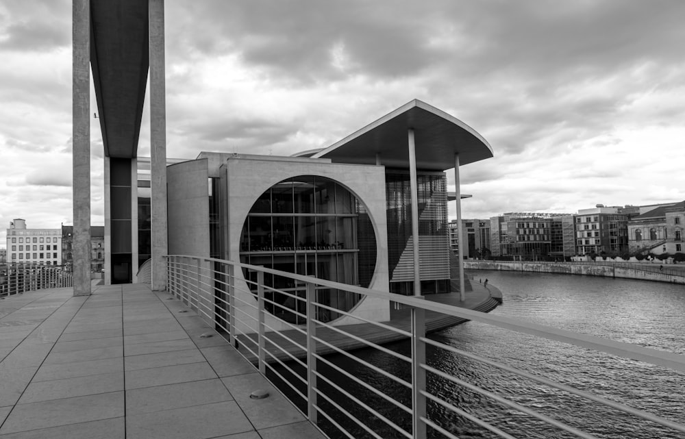 a black and white photo of a walkway next to a body of water