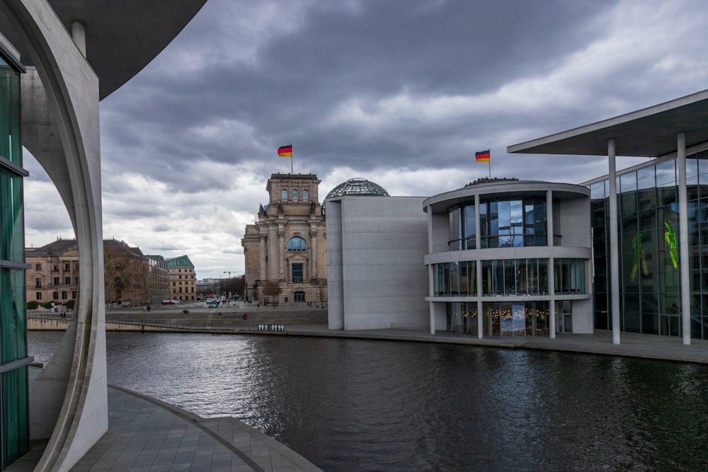 a building next to a body of water under a cloudy sky