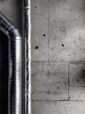 a black and white photo of pipes and a wall
