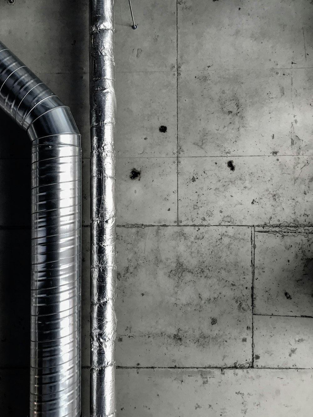 a black and white photo of pipes and a wall