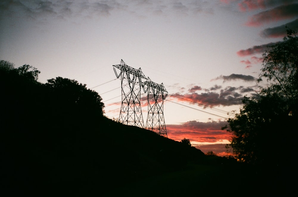 two black transmission towers during golden hour