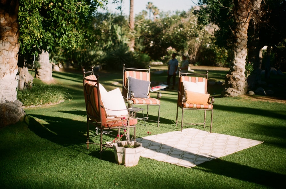 a couple of chairs sitting on top of a lush green field