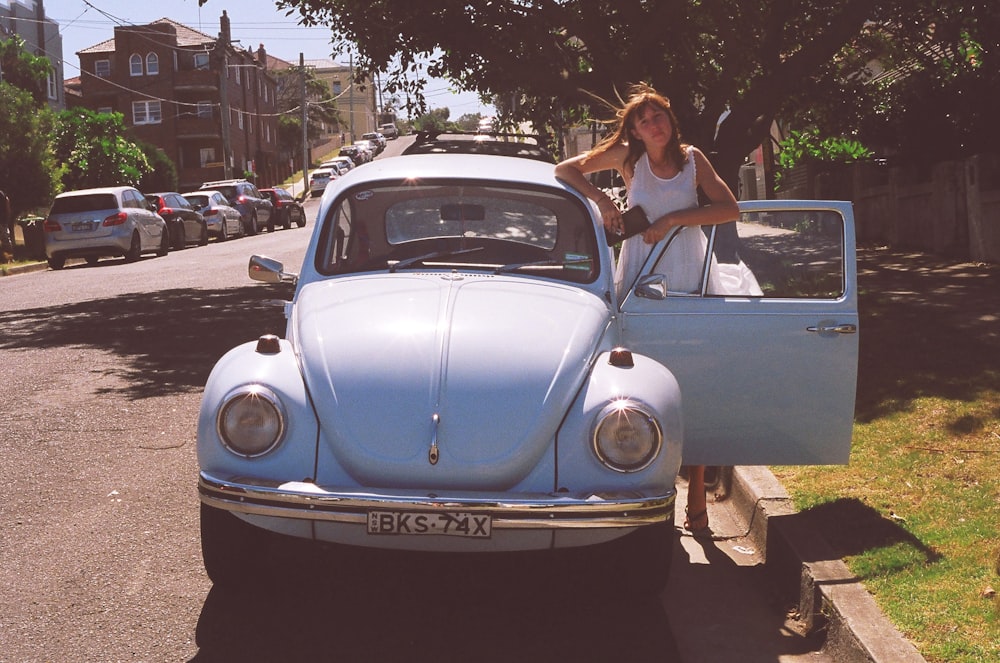 mujer de pie junto a Volkswagen Beetle