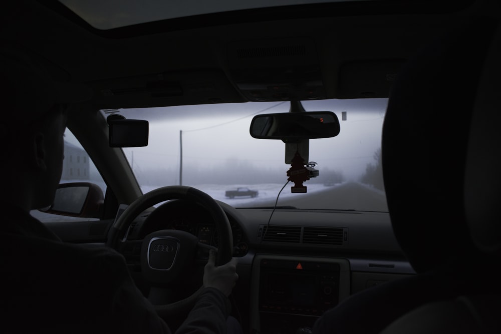 a man driving a car on a foggy day
