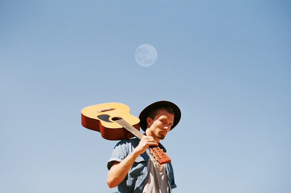 man carrying guitar