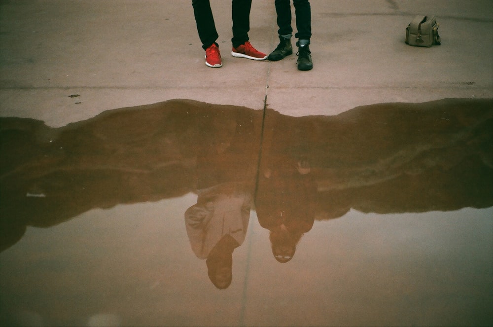 a reflection of two people standing next to each other