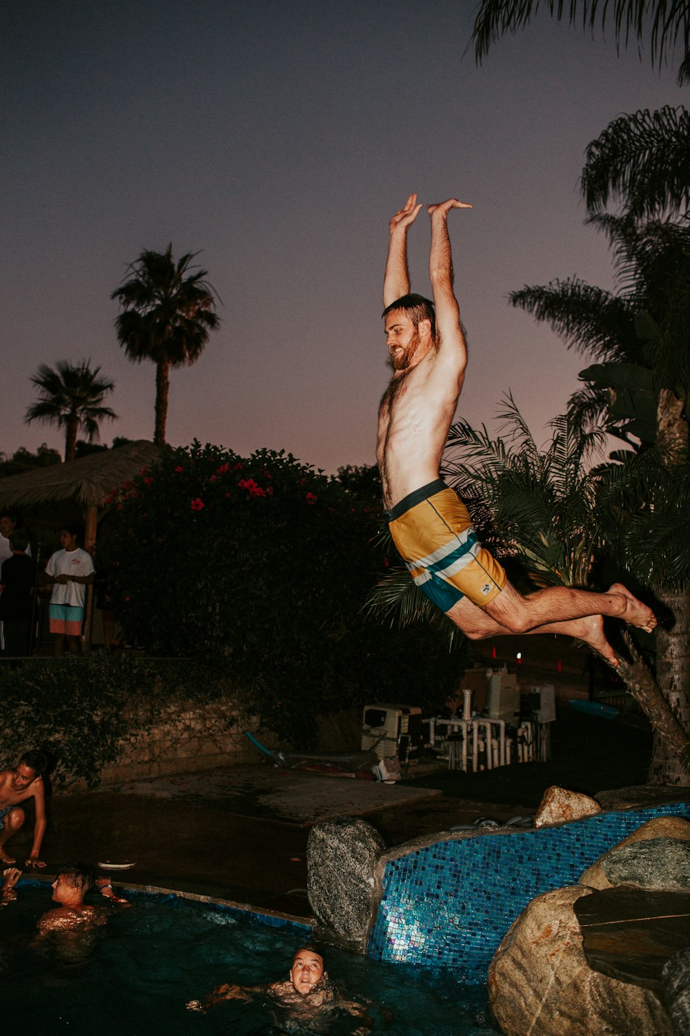 man jumping towards pool