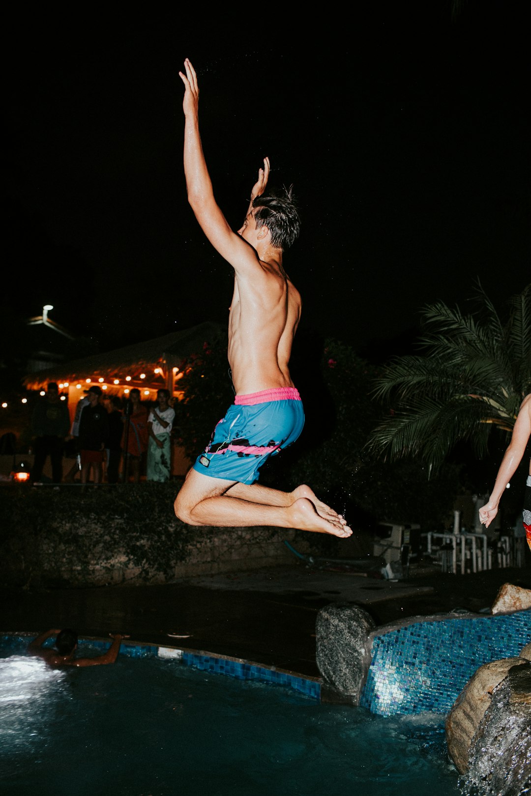 man jumping towards pool